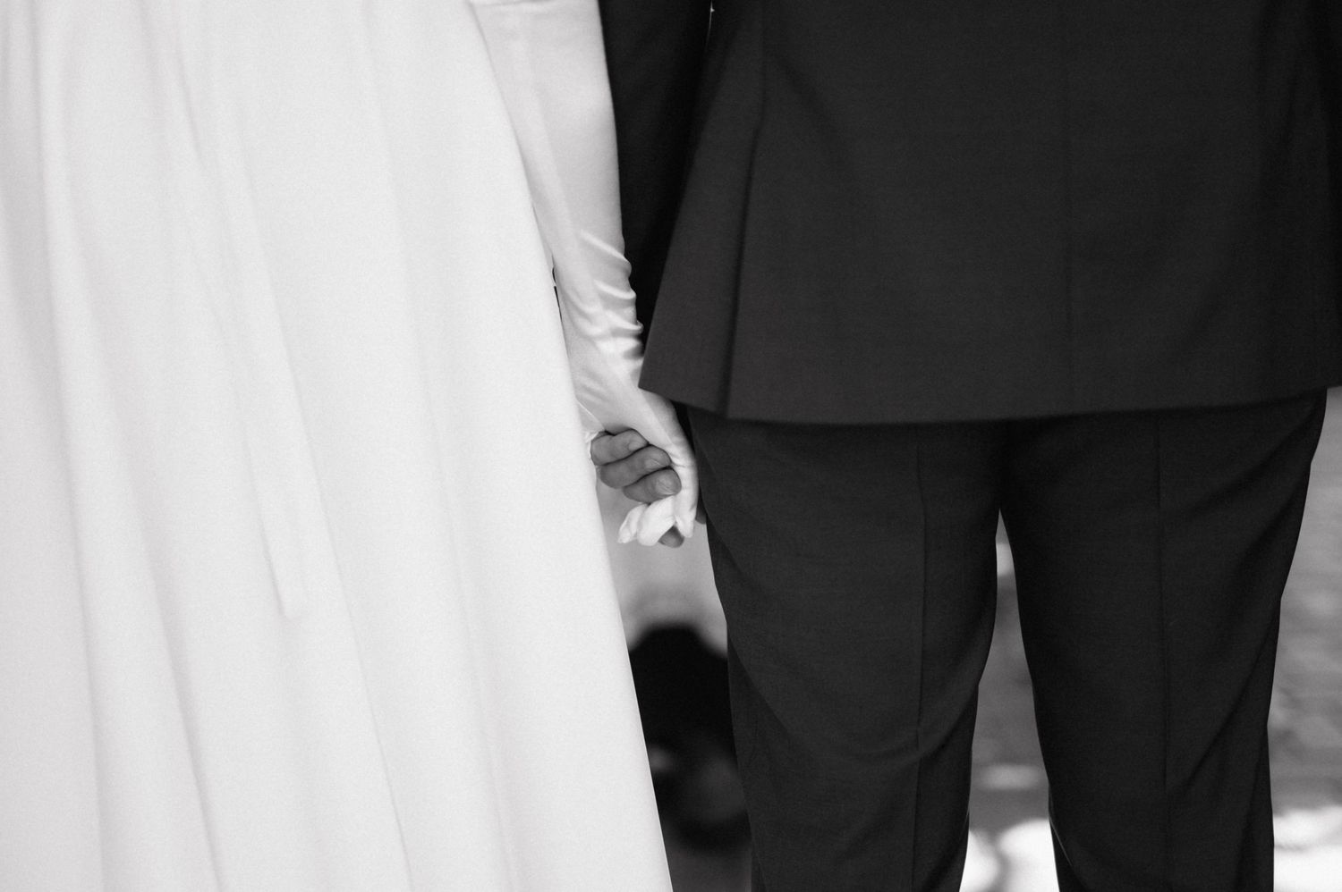 A group stands in formal attire with black tuxedos and white dresses at an elegant event.