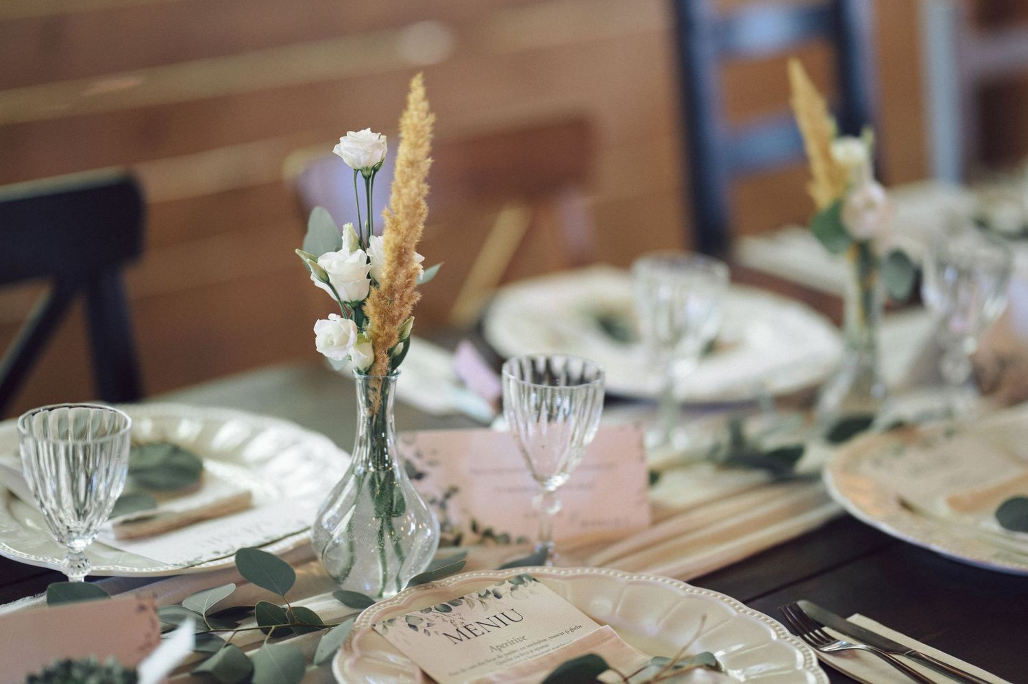 Elegant table settings with soft blue and gold accents feature classic white china plates and crystal glassware.