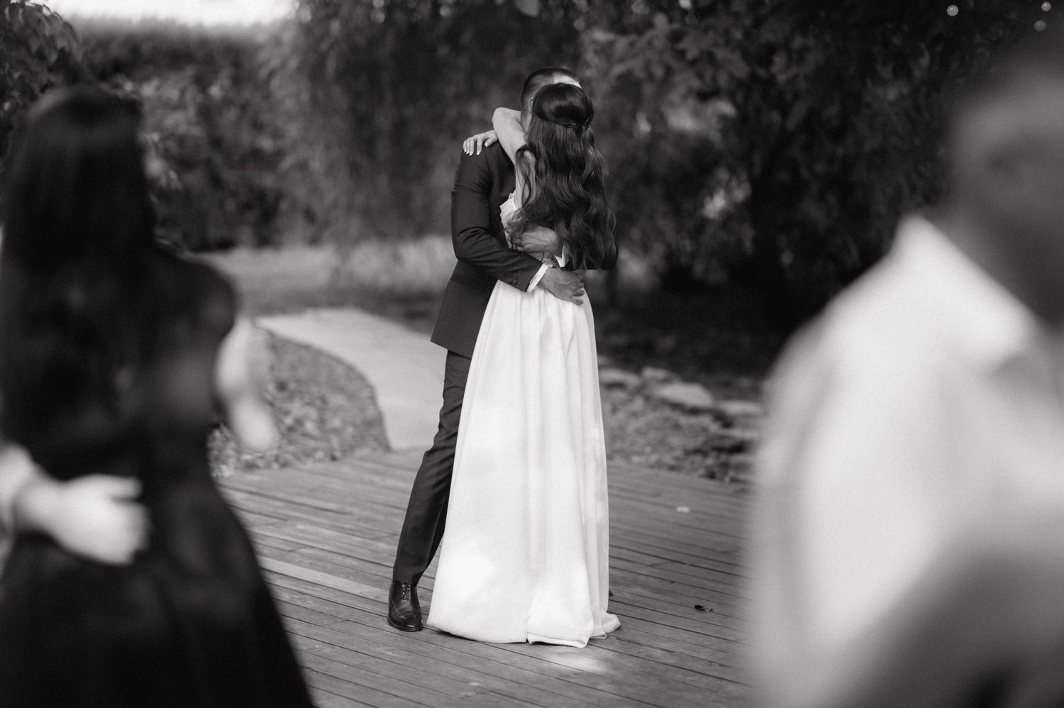 A sequence of black and white photos showing vignettes of a bride in her wedding gown dancing outdoors on a wooden deck.