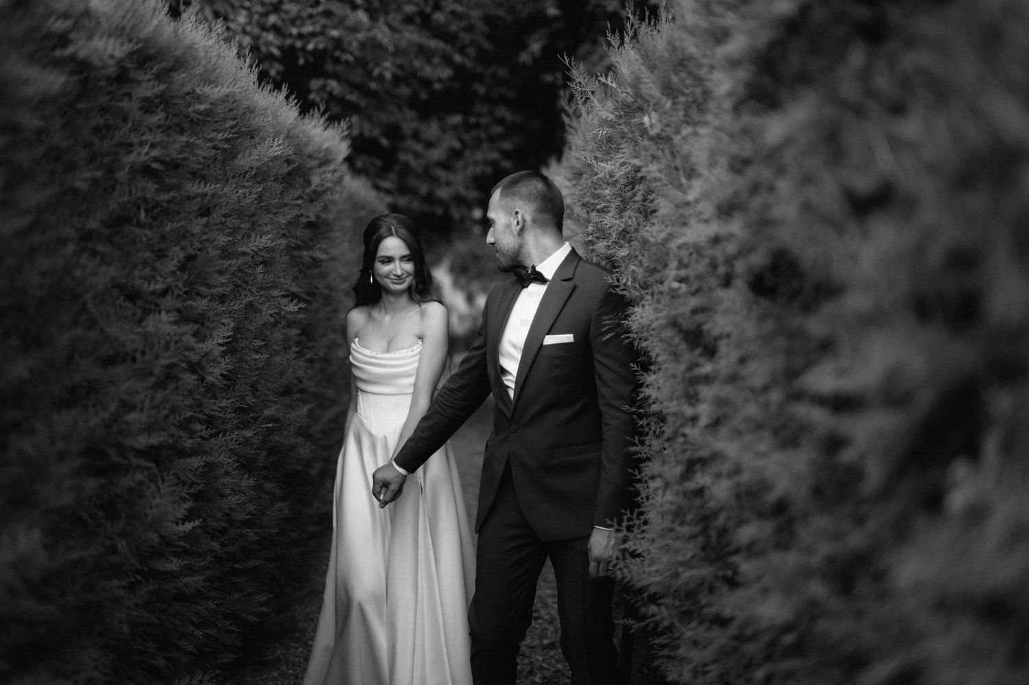 Elegant black and white wedding portraits in a lush garden setting.