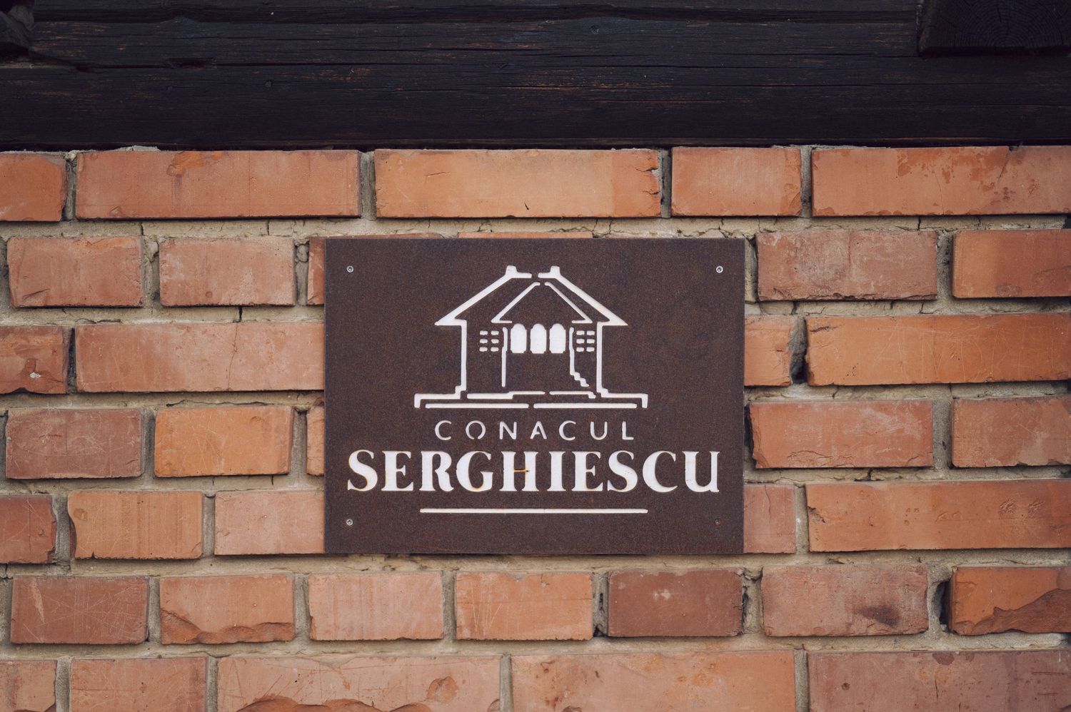 Brown brick wall texture with modern house logo signage mounted against rustic architectural background.