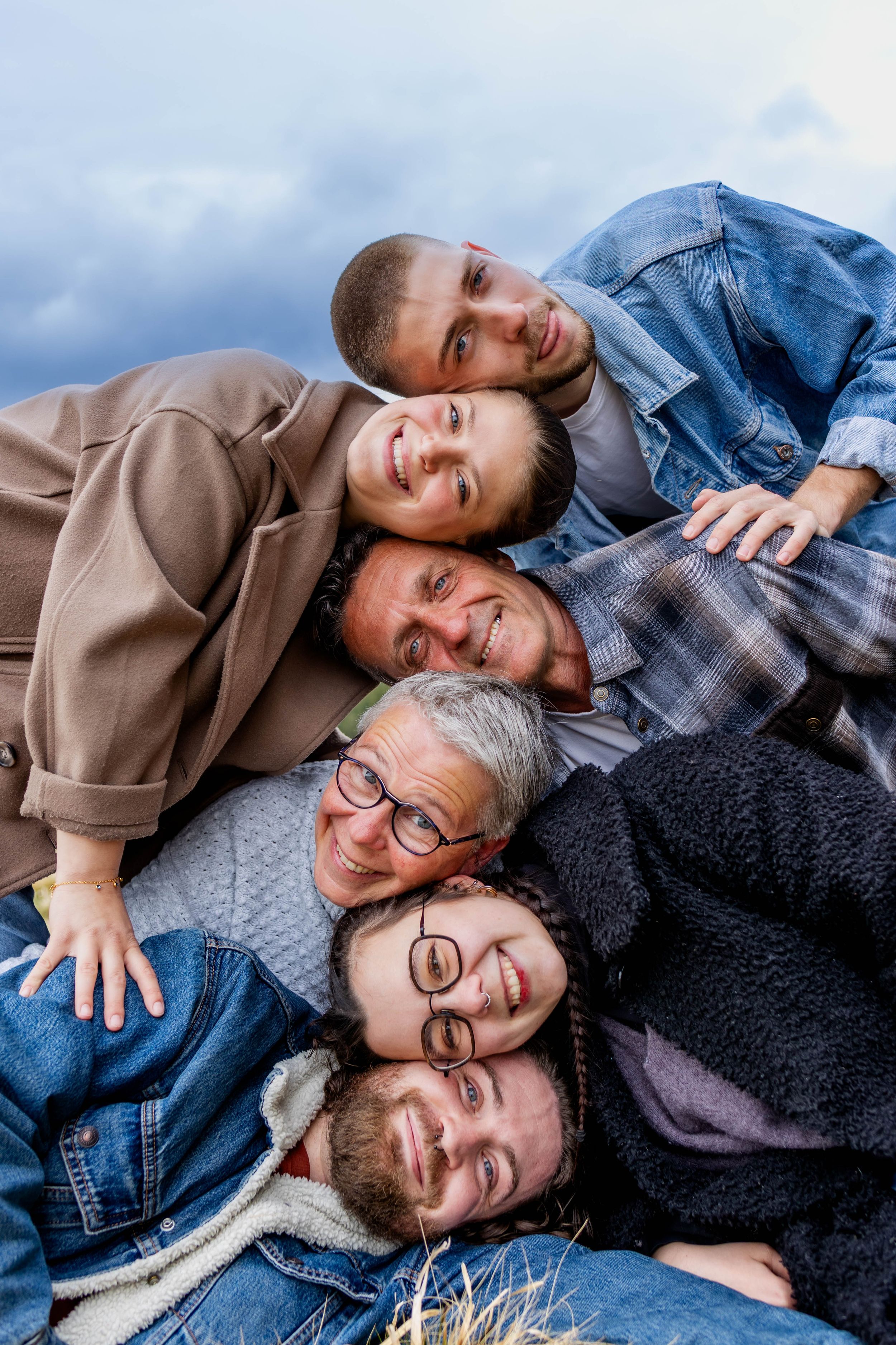 Famille souriante au coucher du soleil dans un champ de blé – séance lifestyle à l'extérieur