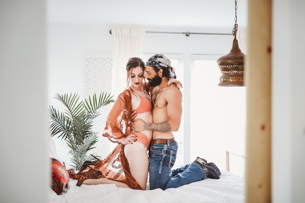 Couple in casual attire creating intimate moments in sunlit boho room.