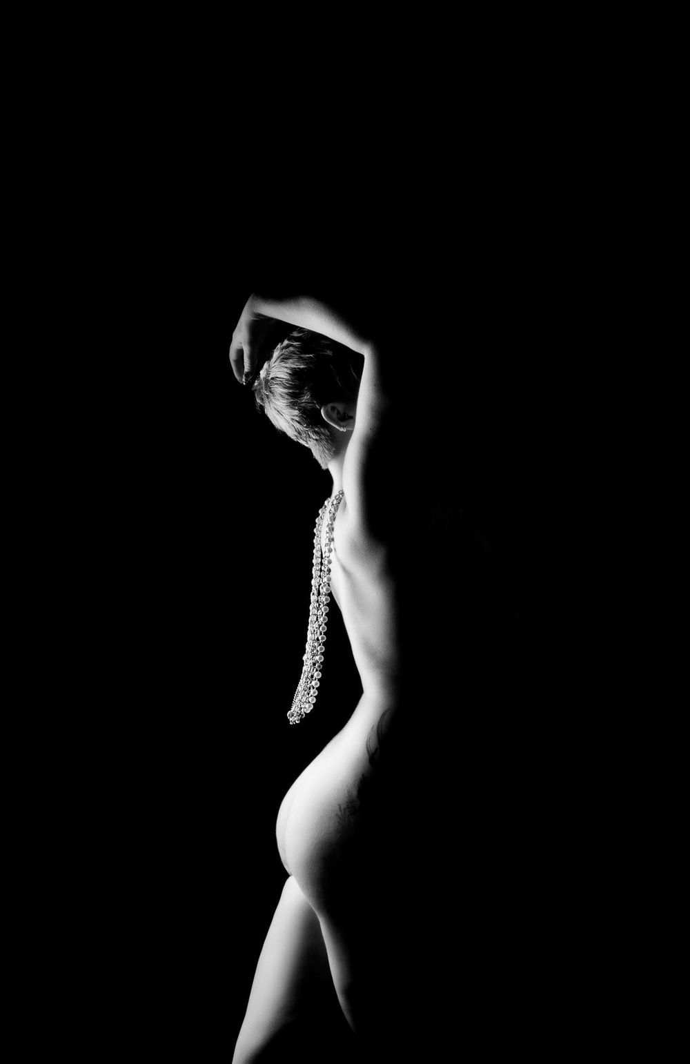Minimalist silhouette photography series against dark background highlighting body curves.