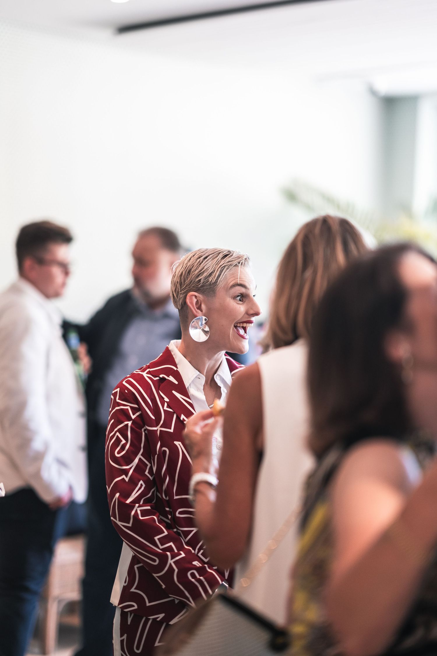 Guest in a patterned red outfit enjoying themselves at a social gathering.