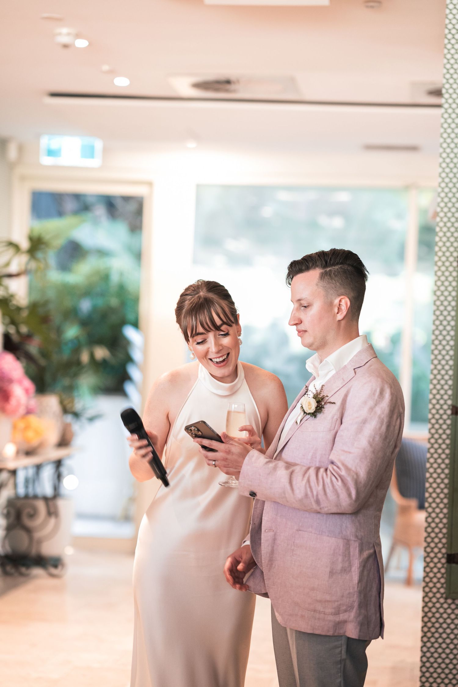 Couple looking at their phones together during a wedding reception.