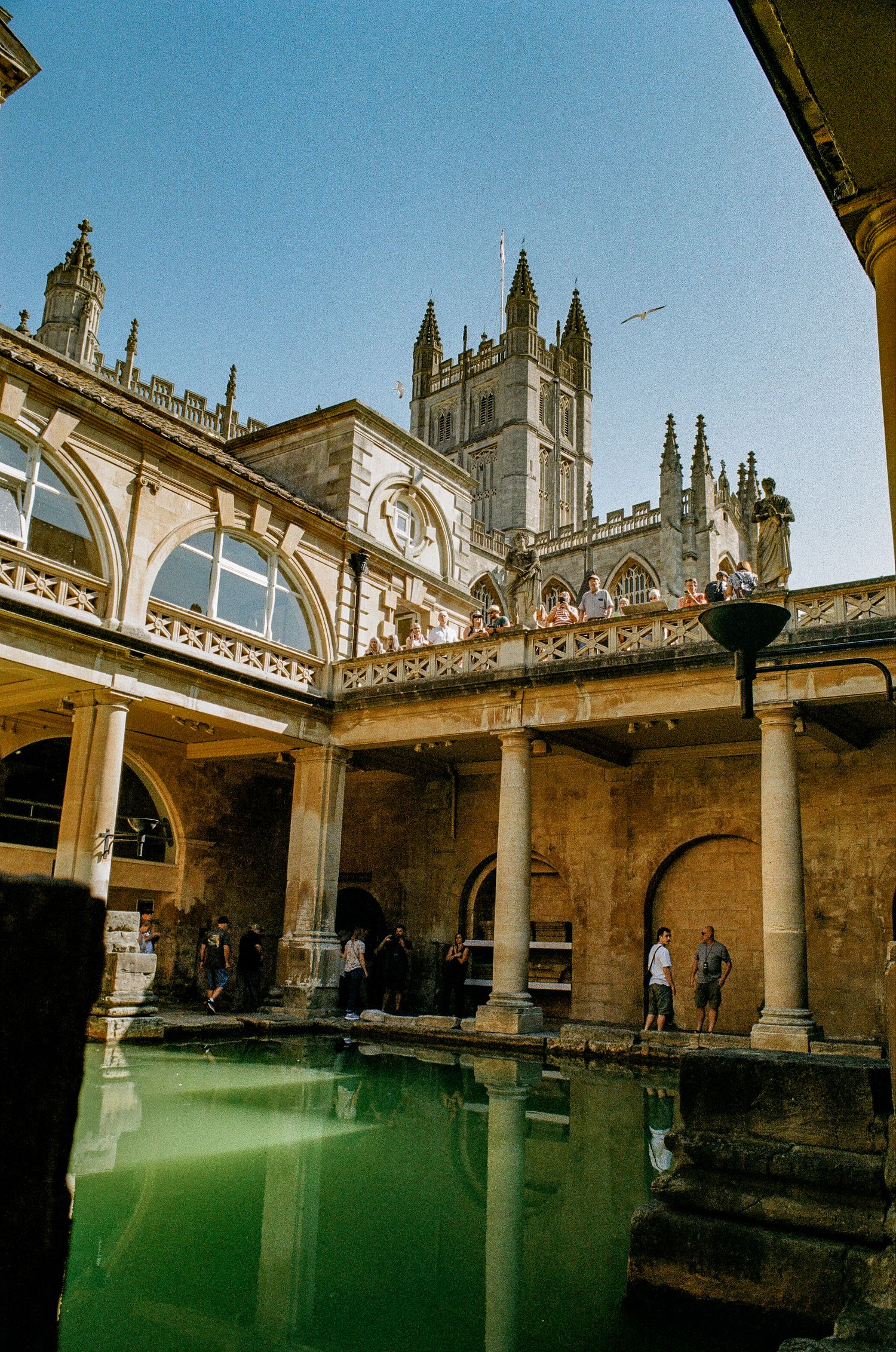 Roman Baths in Bath, England showing ancient architecture and green thermal pool water.