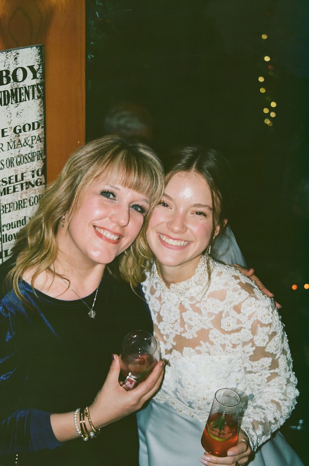 Two friends sharing drinks and smiles at a casual celebration with cowboy-themed decor.