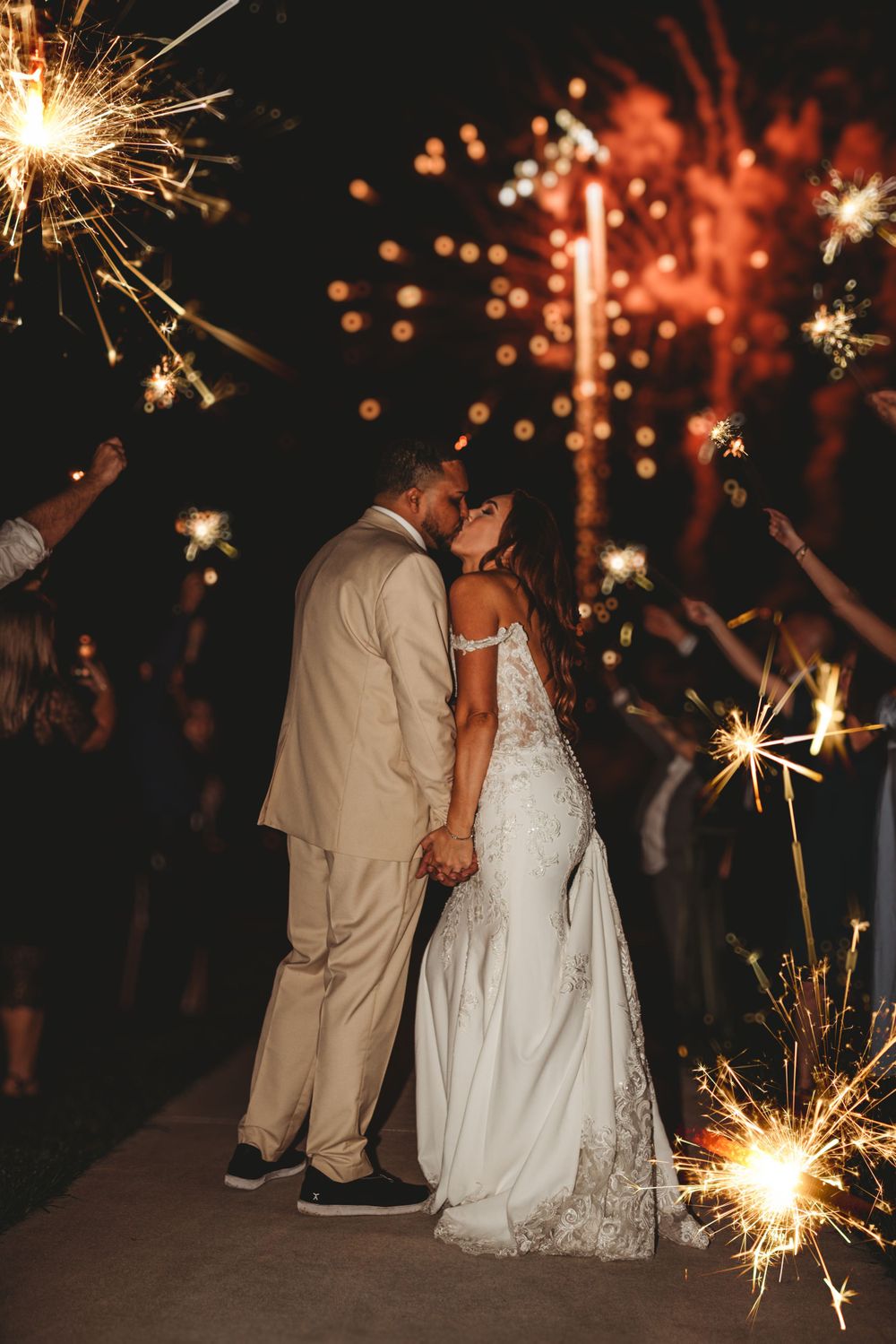 Romantic sparkler moment at night as newlyweds share an intimate moment.