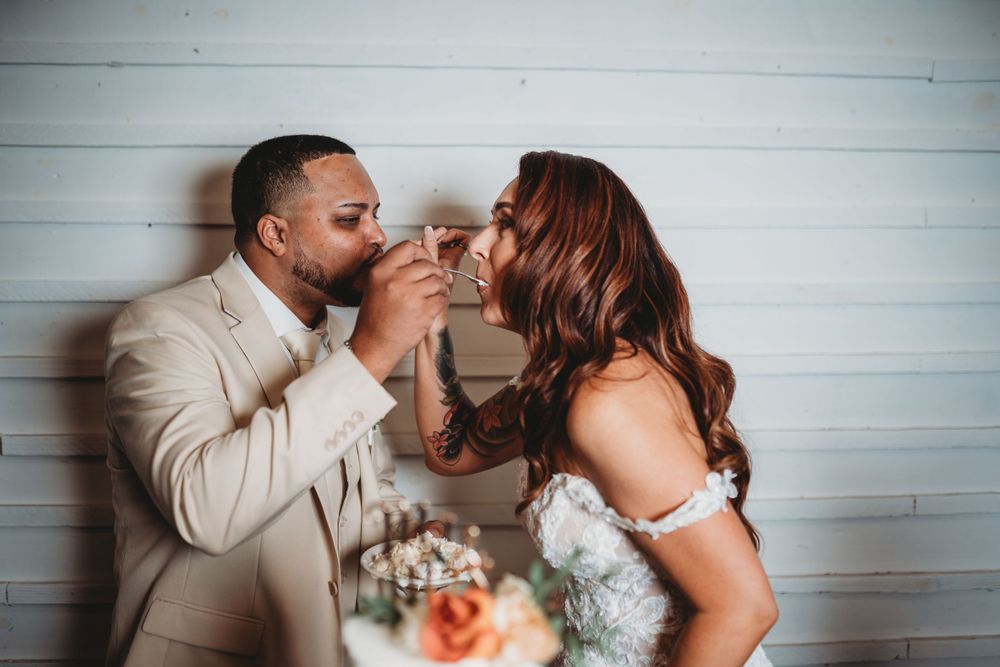 Newlyweds in formal attire sharing champagne during their wedding celebration.