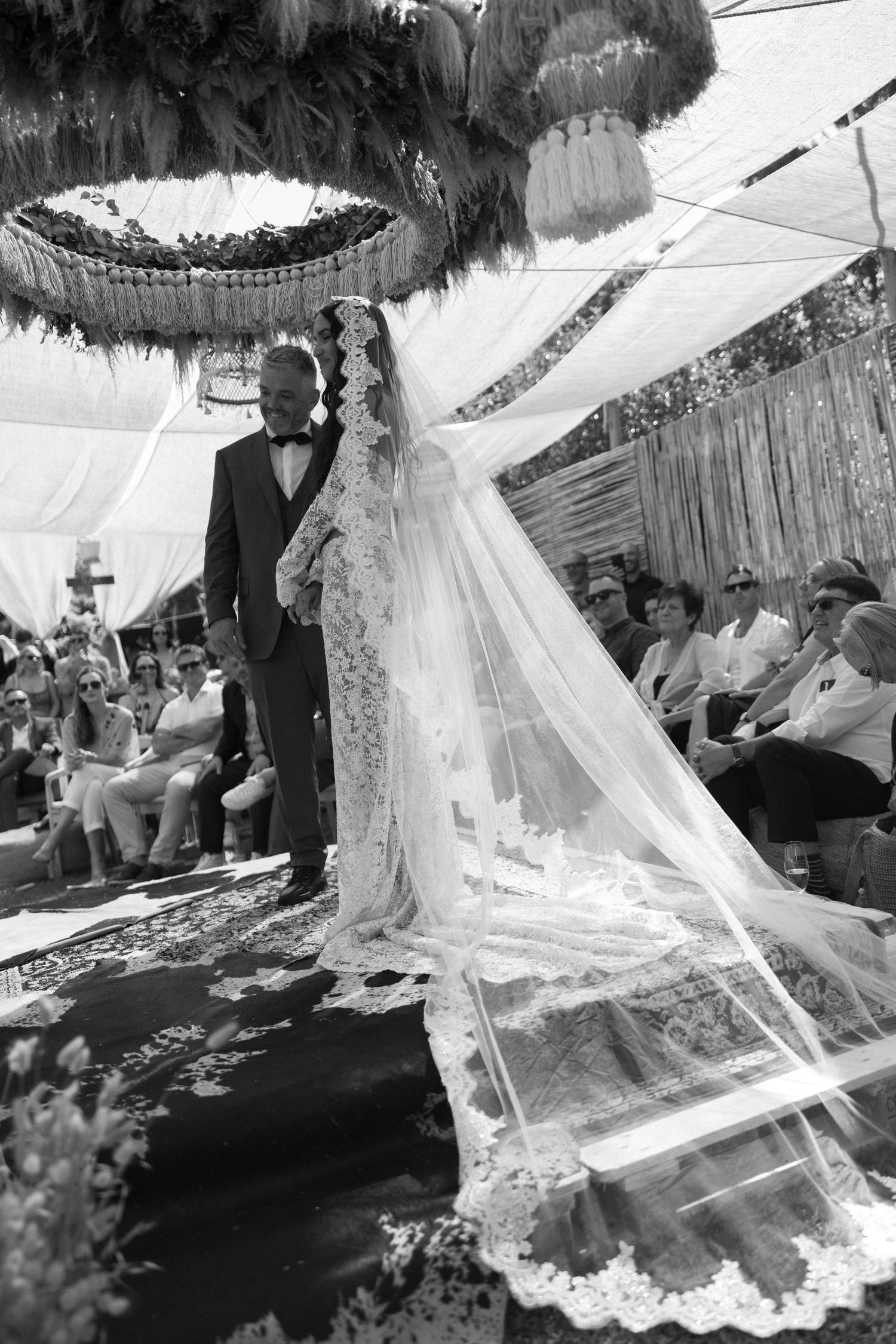 Black and white wedding photo series showing flowing lace veil details and ceremony moments from various angles.