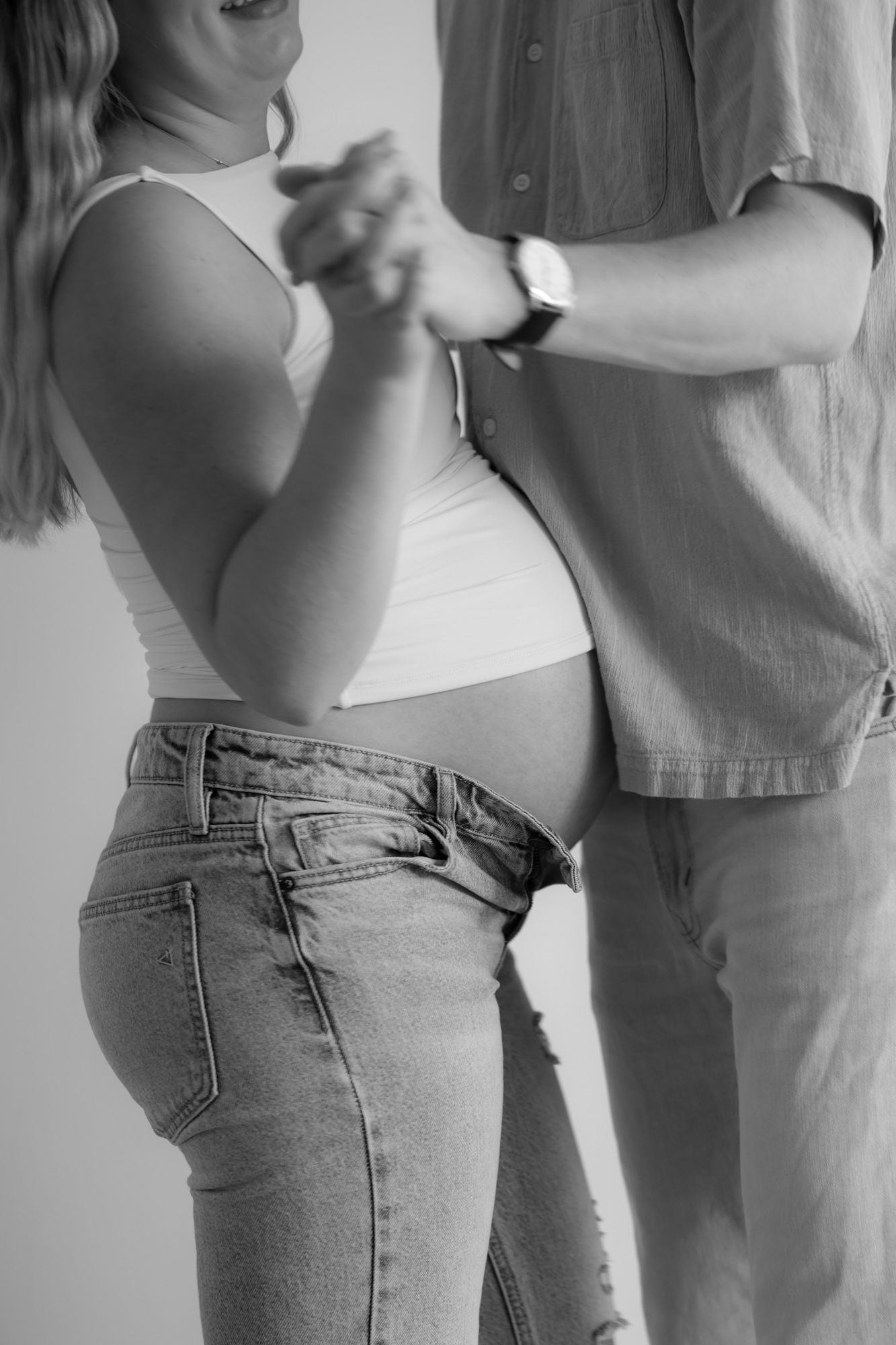 Black and white photos showing cropped views of people in casual denim and light colored clothing embracing.