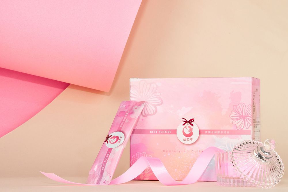Pastel pink stationery items and ribbons arranged artistically on a cream-colored surface.