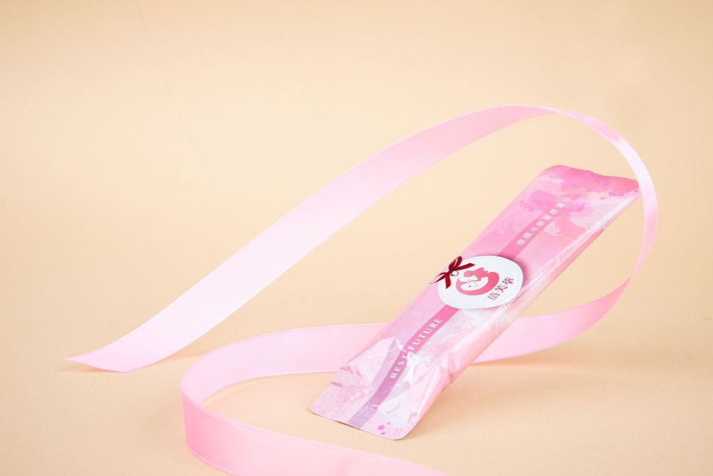Pink ribbons and decorative elements creating an elegant border design on a neutral beige background.