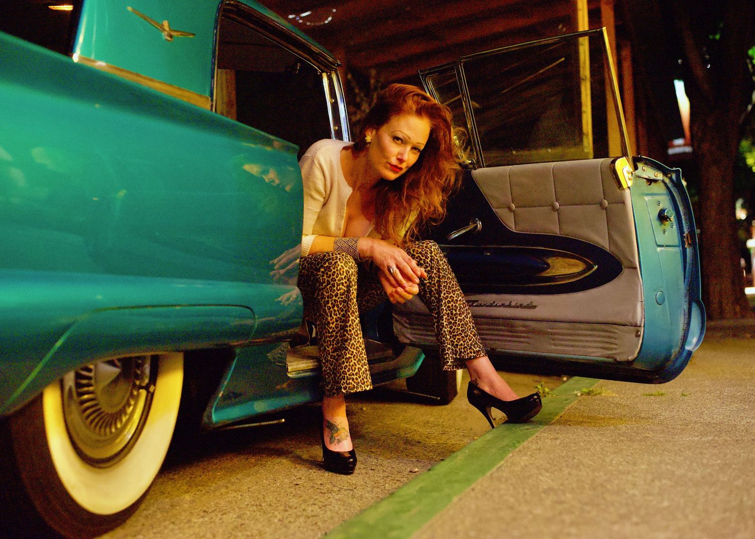 Photograph of beautiful redhead woman leaning out of a green Ford Thunderbird in Fairfax California by William Wayland