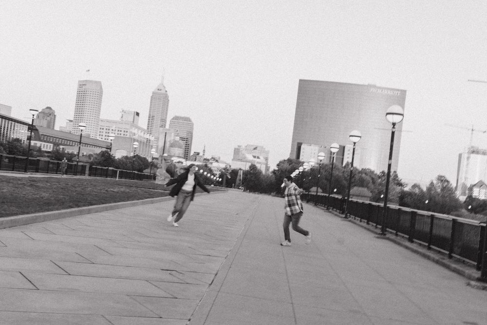 A sequence of black and white photographs showing skateboarders performing tricks against an urban skyline backdrop.