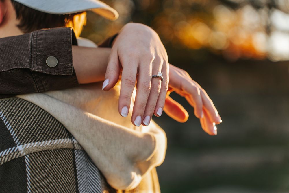 Close-up shot of hands holding a camera in golden sunlight with shallow depth of field.