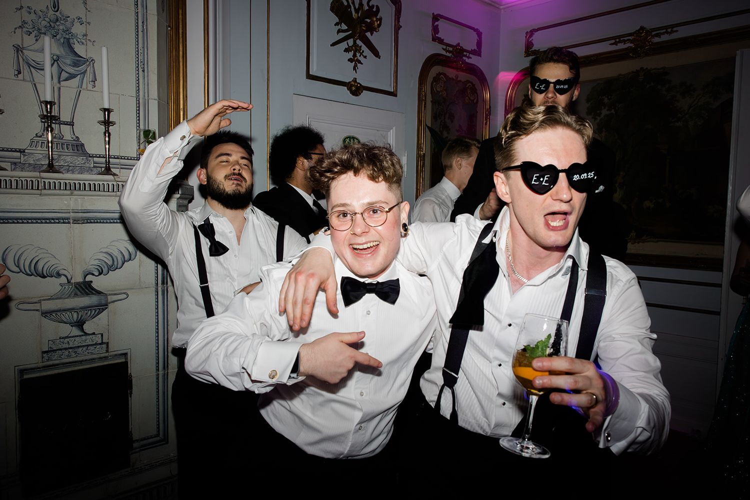 People dancing and socializing at a dimly lit party or nightclub event.