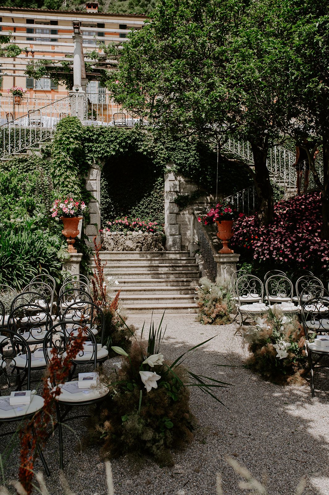 Stone staircase garden venue with elegant table settings and ornate iron railings.