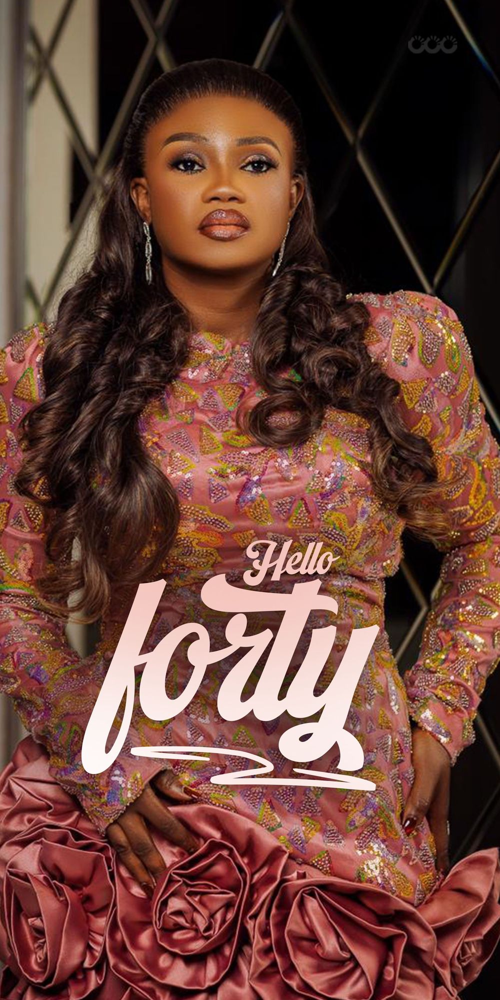 A glamorous portrait featuring a woman in a pink floral dress with long curly hair and "Hello forty" text overlay.
