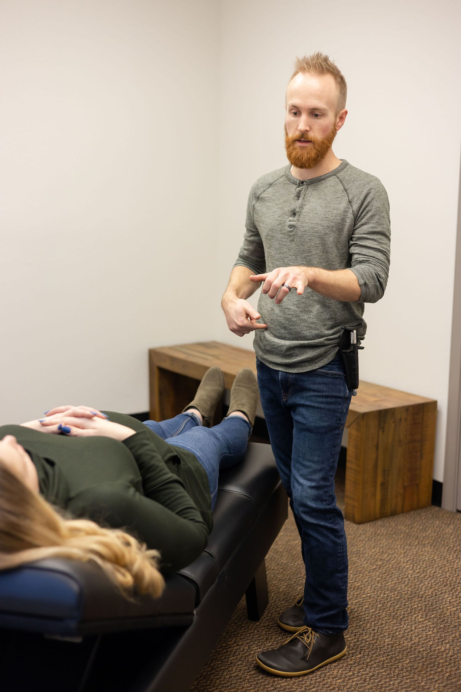 chiropractor branding photo in Sumner, WA wellness health man talking to pregnant women about hip alignment for adjustment for treatment