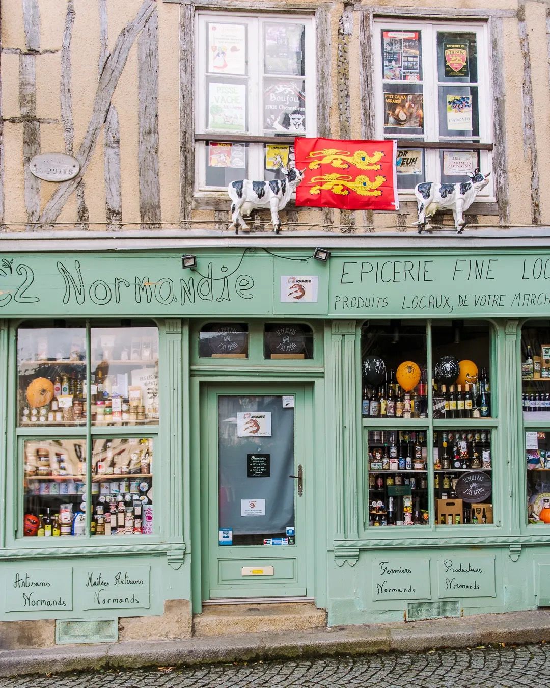 Charming mint green French shopfront with vintage signage and a colourful window display.