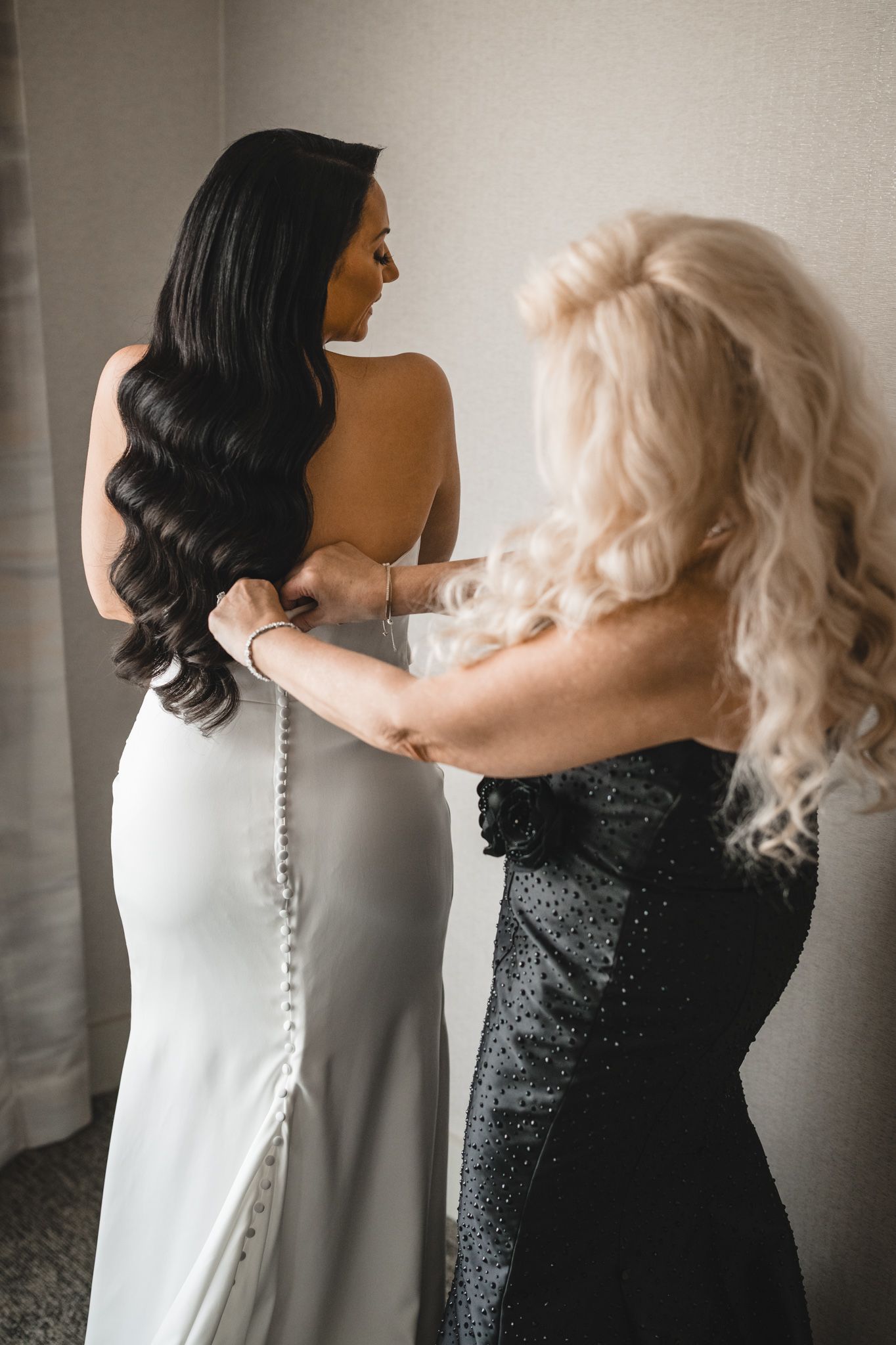 Wedding dress details showing button closures in black and white photography.
