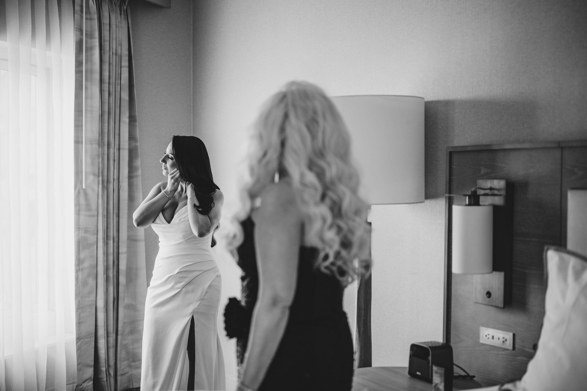 Intimate black and white wedding preparation moments in a hotel room.