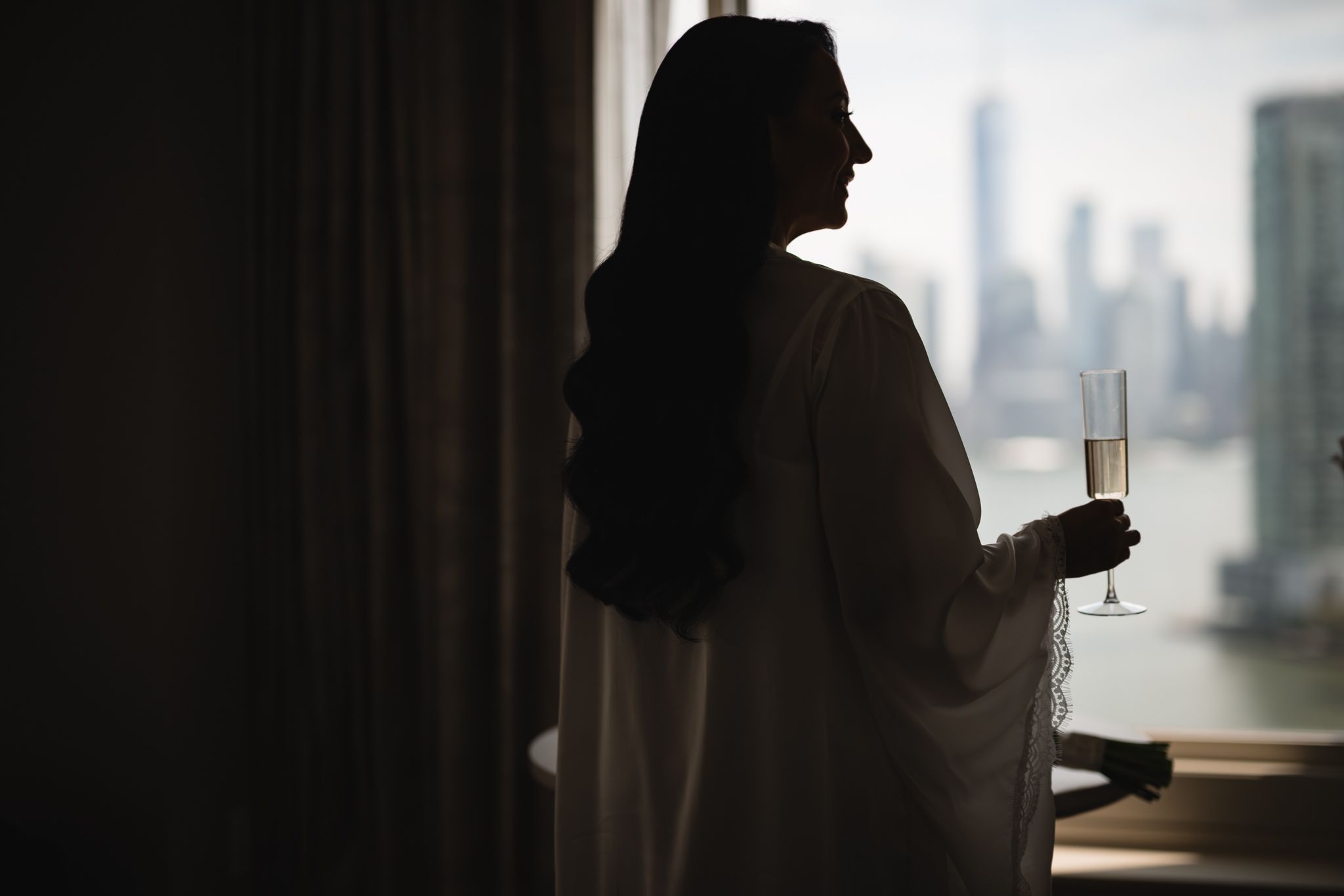 Silhouettes against large windows with city skyline views.