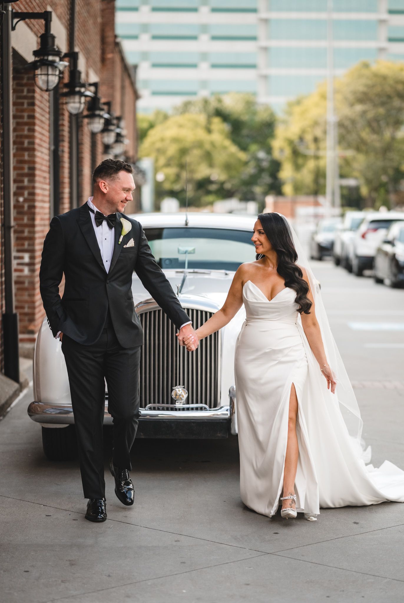 Playful wedding photo series showing couple's interactions along brick building exterior.