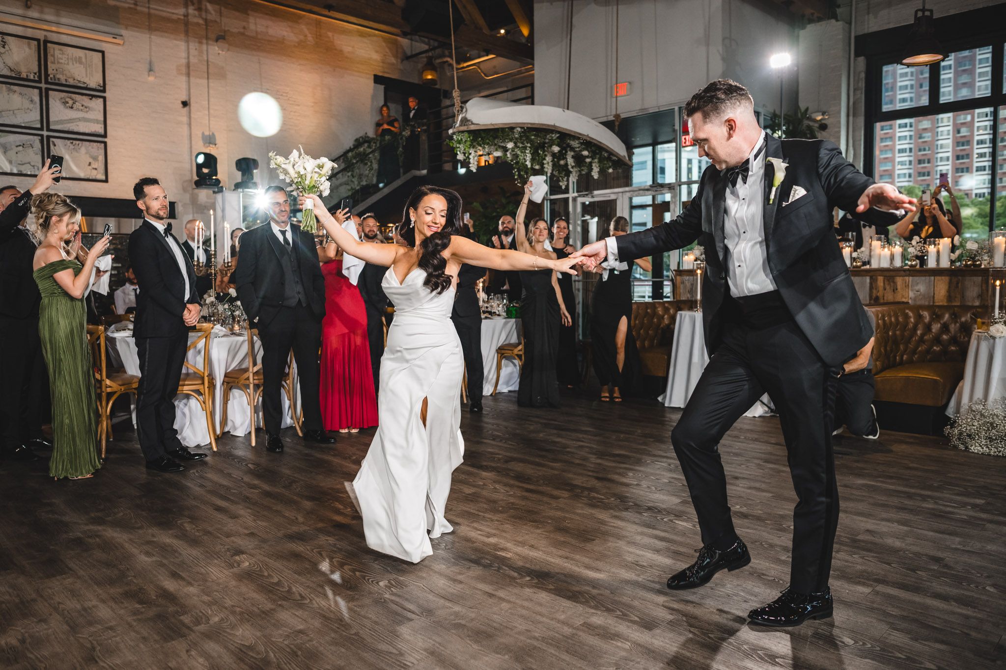 Lively dance floor scene at a wedding reception with guests in formal attire.