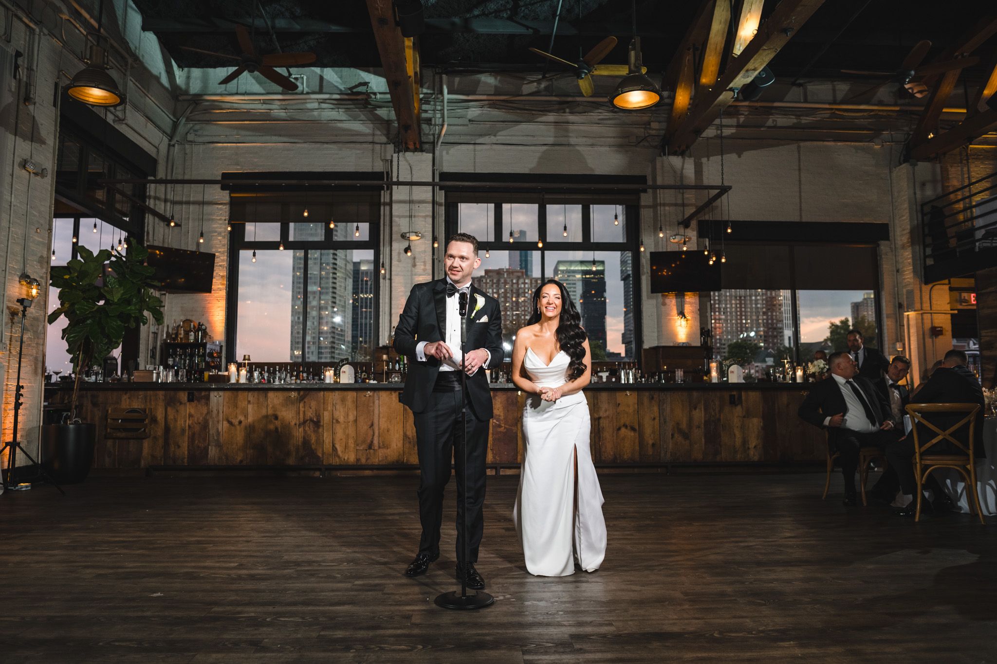 Spacious wedding venue with industrial-chic decor and warm ambient lighting.
