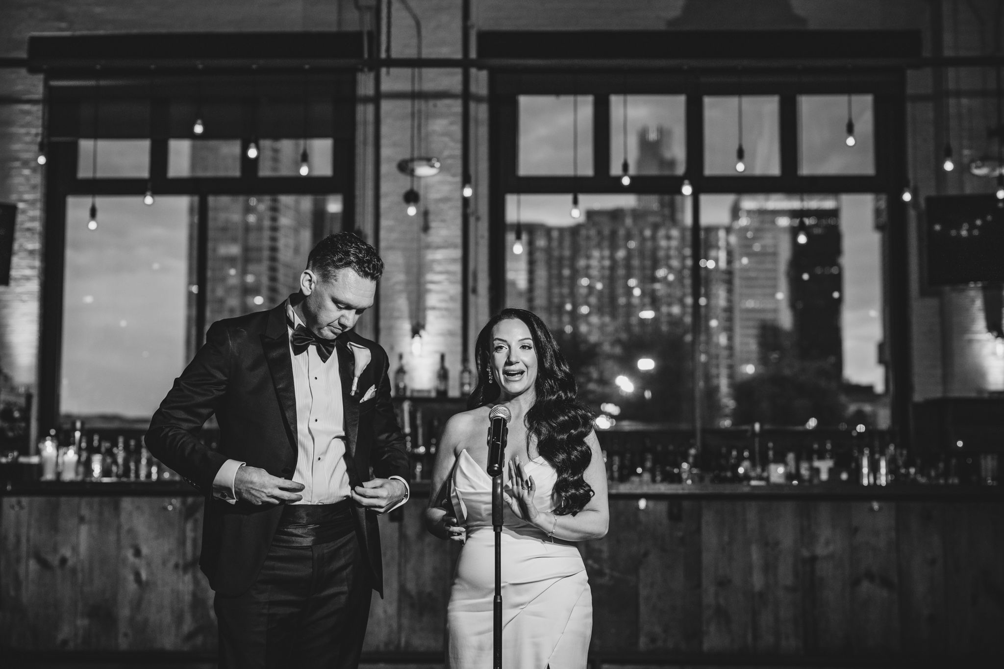 Modern industrial wedding venue with large windows and ambient lighting.