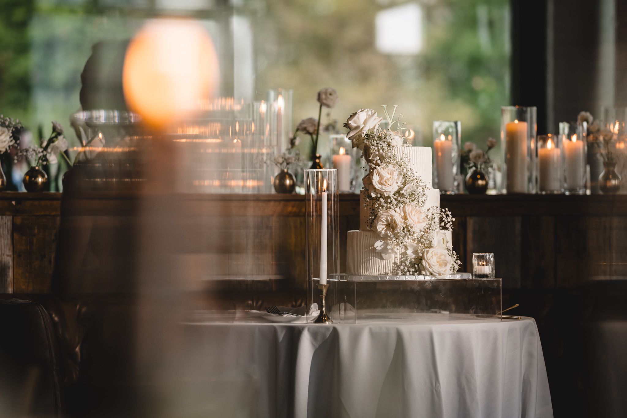 Romantic wedding table setting with soft candlelight and neutral floral centerpieces.