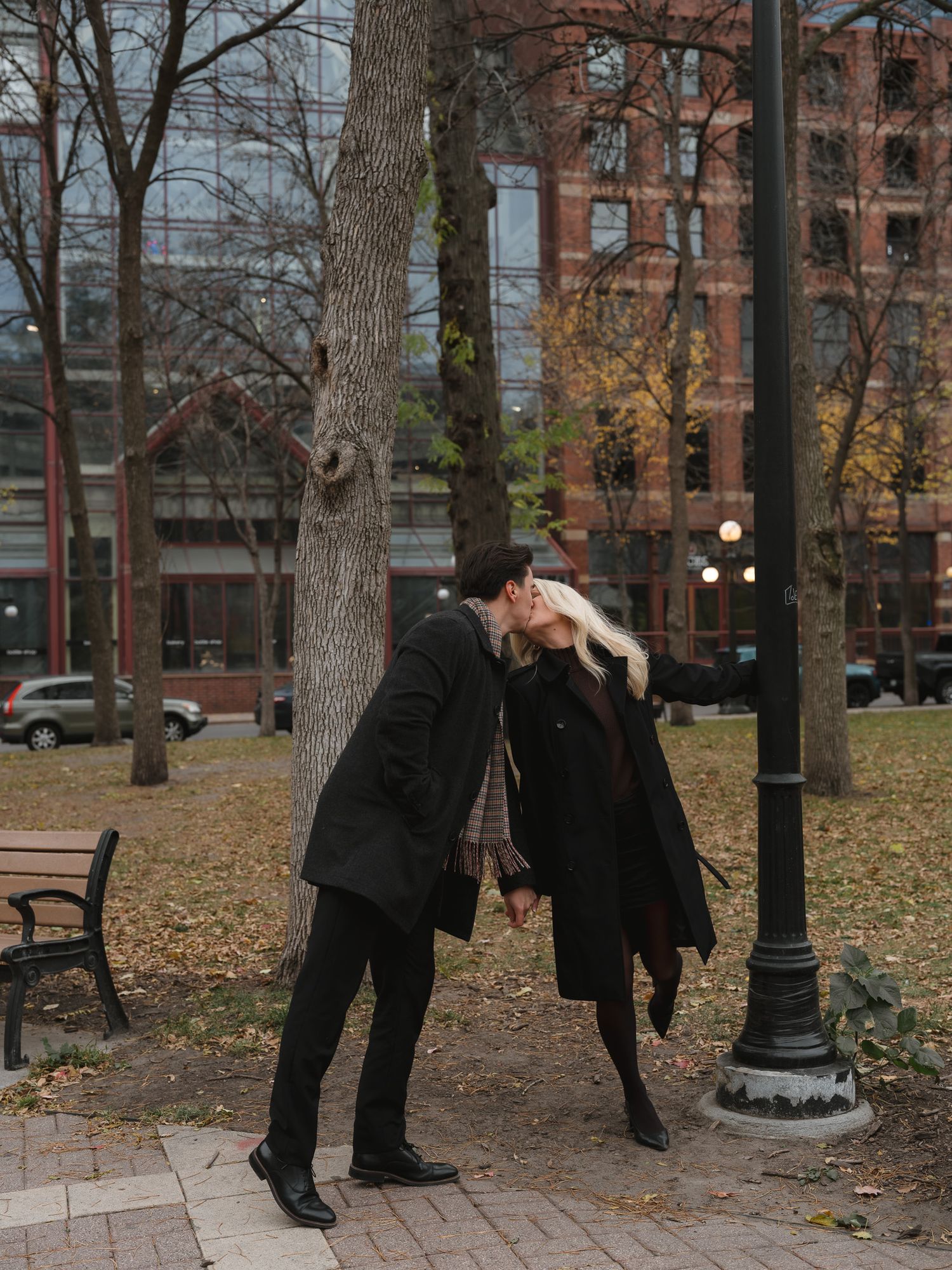 A sequence of four photos showing two people dancing and spinning together in a park with autumn leaves on the ground.
