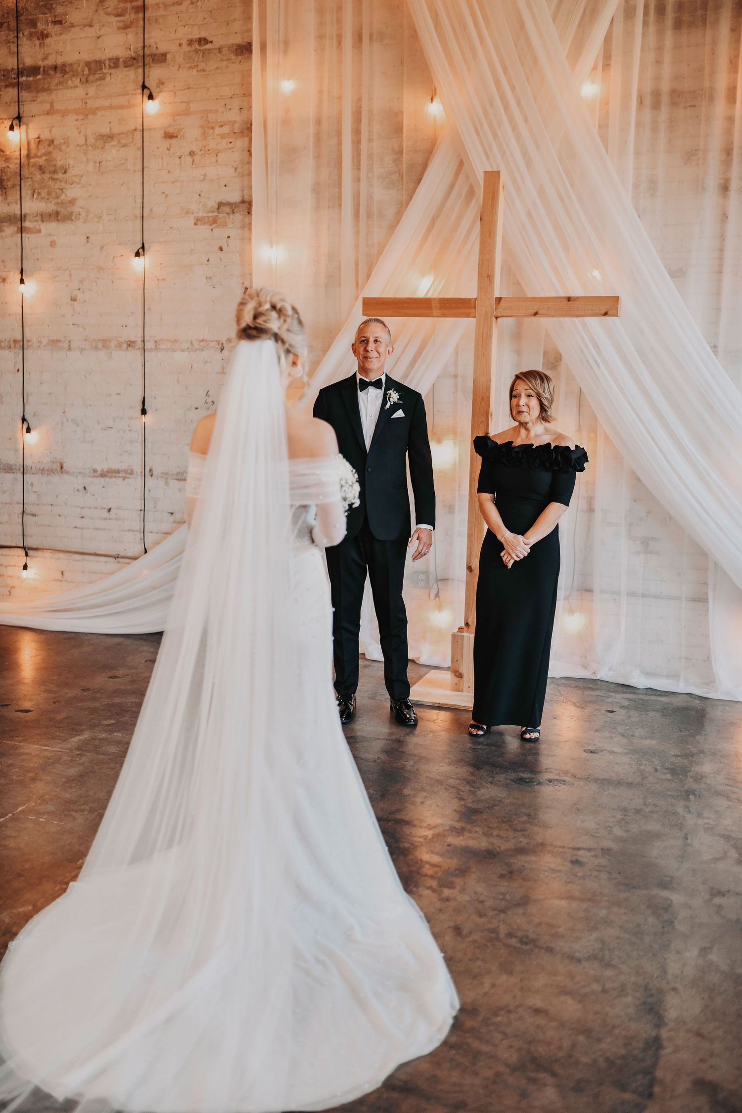 Bride shares an emotional first look with her parents at Brake & Clutch Warehouse, tears and smiles captured in soft, modern editorial style