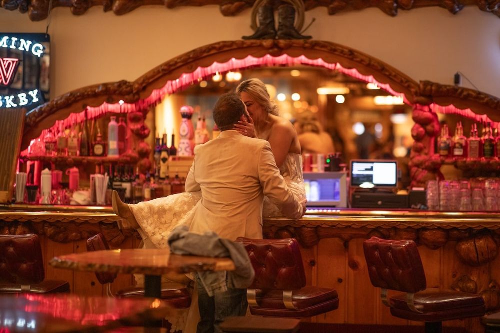 Dimly lit retro diner interior with red neon lighting and classic counter seating at night.