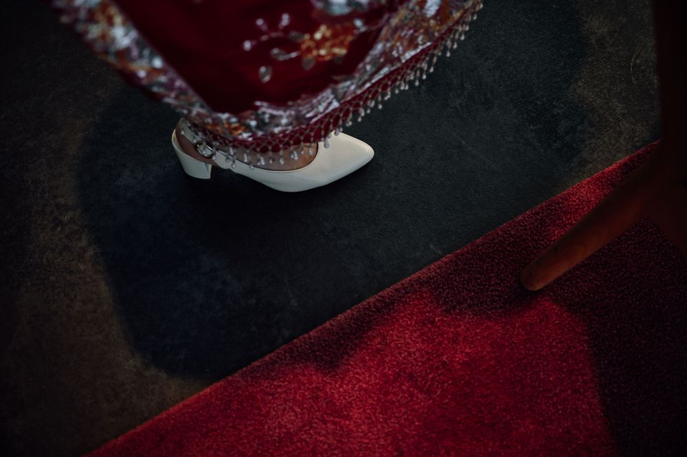 Dark red velvet cupcakes with cream cheese frosting arranged in a moody, dramatic lighting setup.