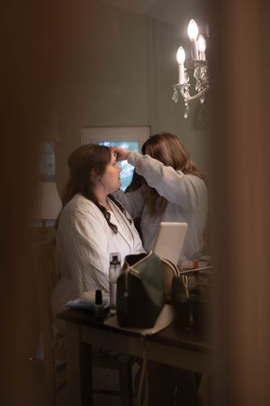 A behind-the-scenes photo of wedding day preparations with a chandelier in the background.