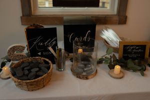 Rustic wedding decor display with candles and wooden elements on a dark surface.