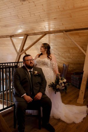 Candid wedding moment captured in warm tones inside wooden-beamed venue.