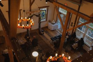 Overhead view of a wedding venue with warm lighting and exposed wooden architecture.