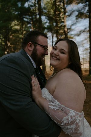 Intimate wedding couple shares tender moments in a sunlit forest setting.