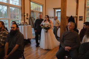 Wide view of a wedding ceremony space with wooden floors and large windows.