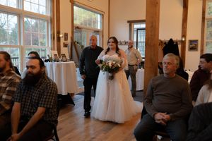 Indoor wedding venue with wooden beams and large windows creating an elegant atmosphere.