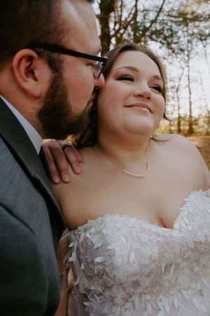 Close-up shots of newlyweds sharing intimate moments in golden forest light.