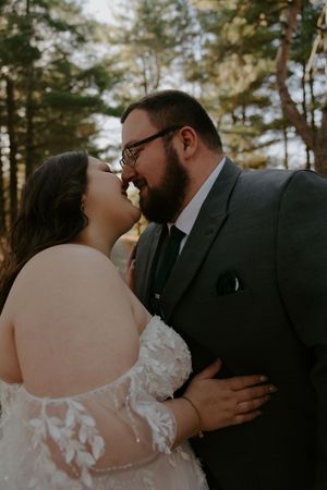 Intimate wedding portraits showing tender moments between newlyweds in forest.
