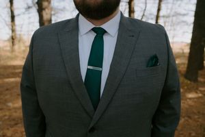 Detail shot of a gray suit with emerald green tie and matching pocket square.