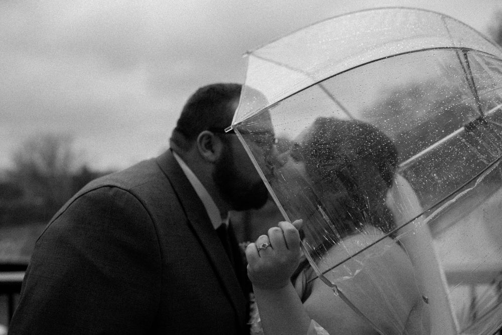 Intimate black and white photos of a couple sharing moments under a clear umbrella.