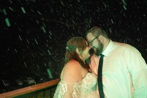 Couple sharing an intimate dance moment under green lighting at their wedding reception.